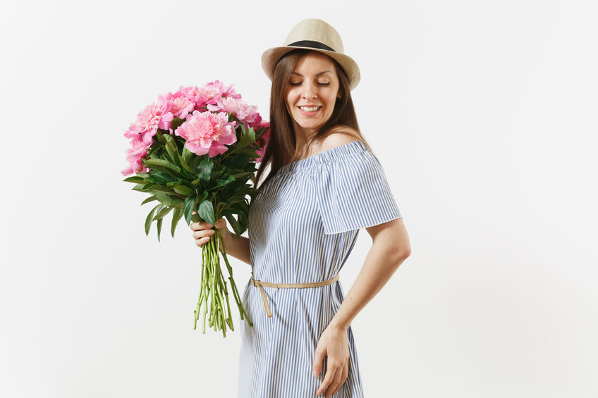 young tender woman in blue dress, hat holding bouquet of beautiful pink peonies flowers isolated on white background. st. valentine's day, international women's day holiday concept. advertising area.