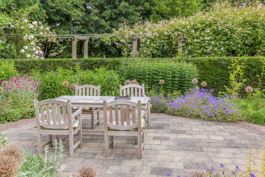 wooden table and chairs in an ornamental garden